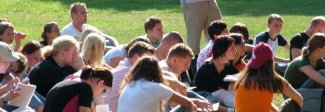 Studenti seduti sul prato sotto il sole