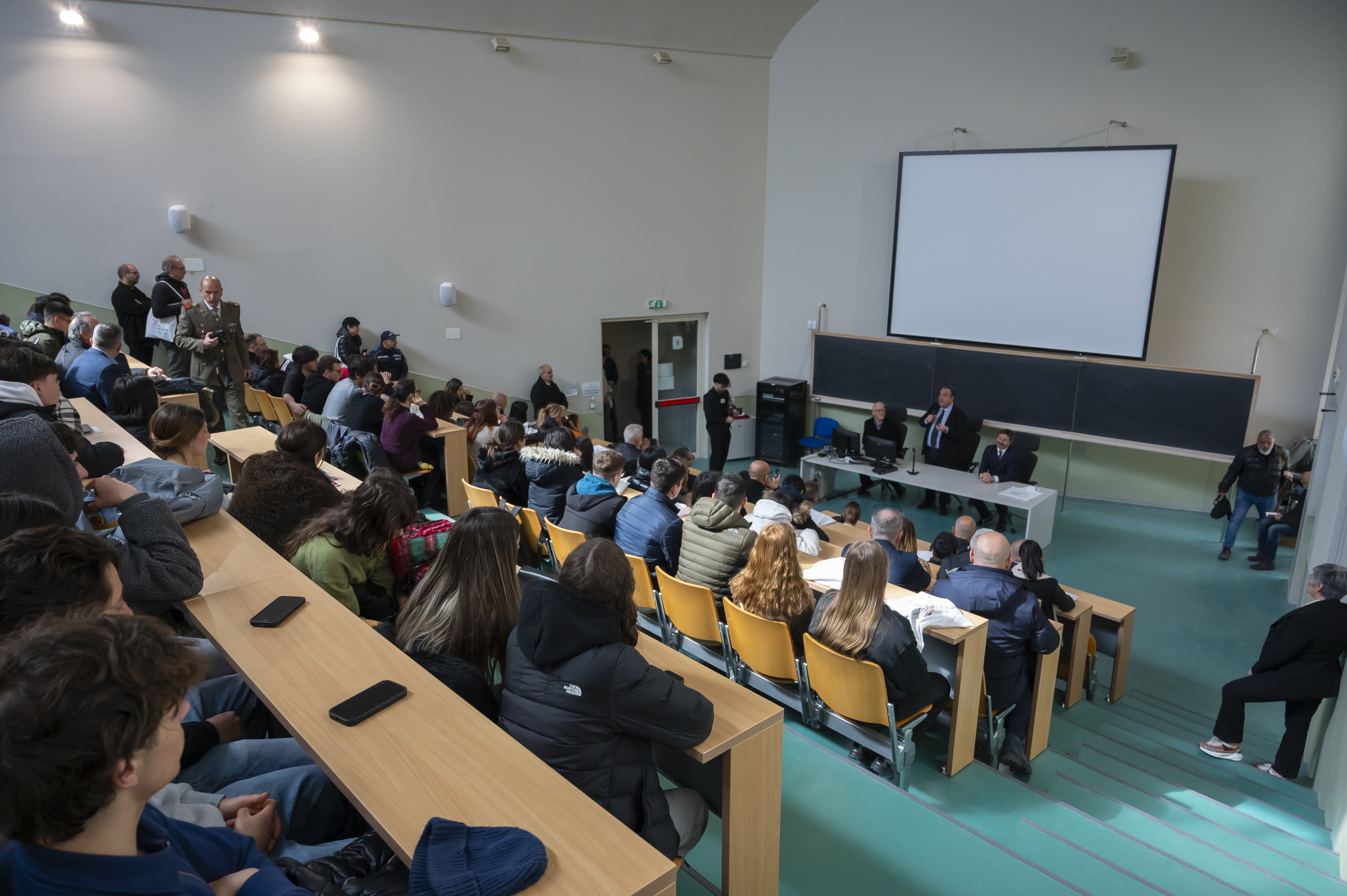 Aula magna affollata durante un incontro di orientamento UNISS, con presentazione istituzionale rivolta a futuri studenti dell’Università di Sassari