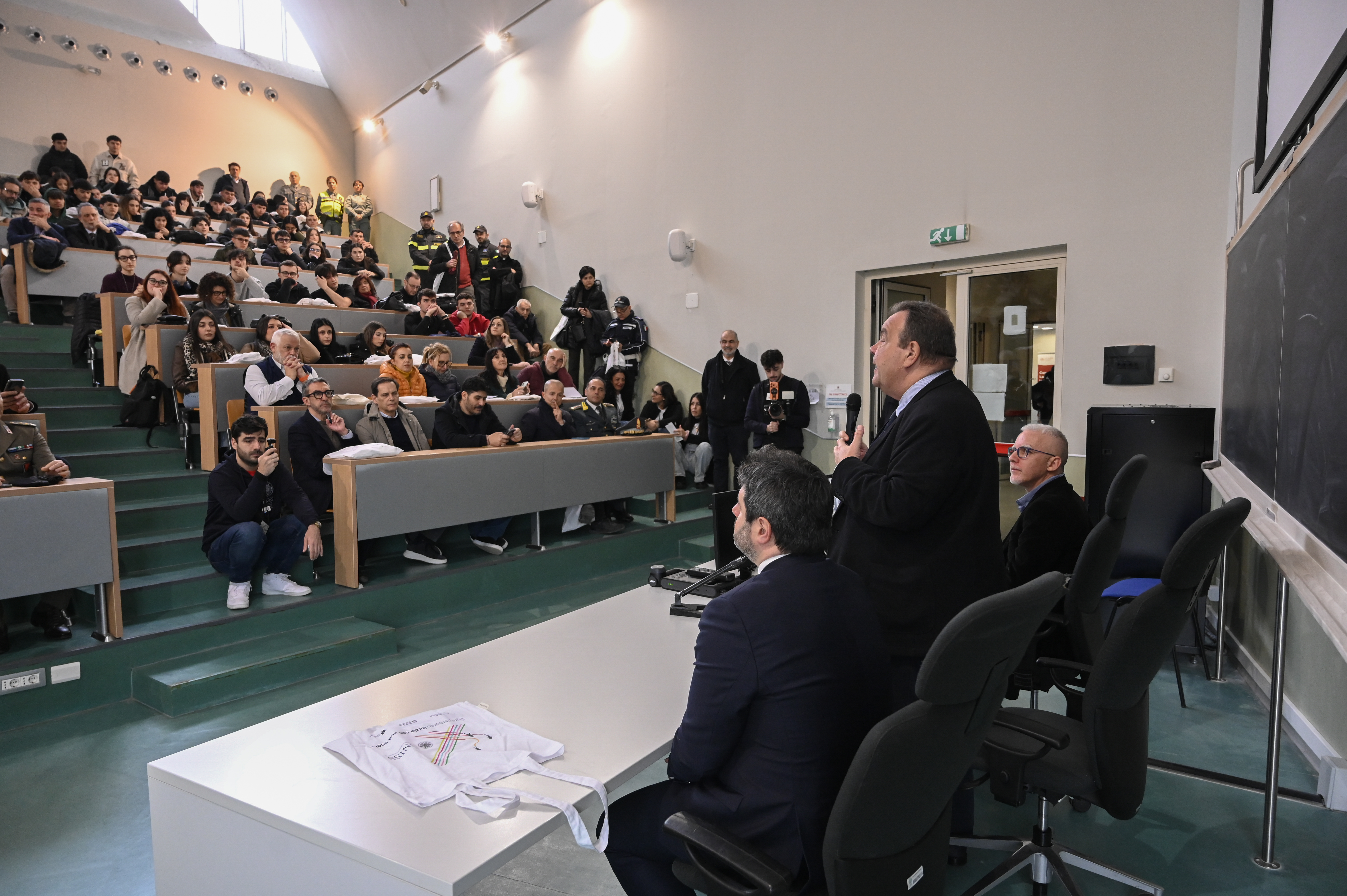 Intervento pubblico durante una conferenza UNISS in aula universitaria, con relatori e numerosi partecipanti alle Giornate dell’Orientamento