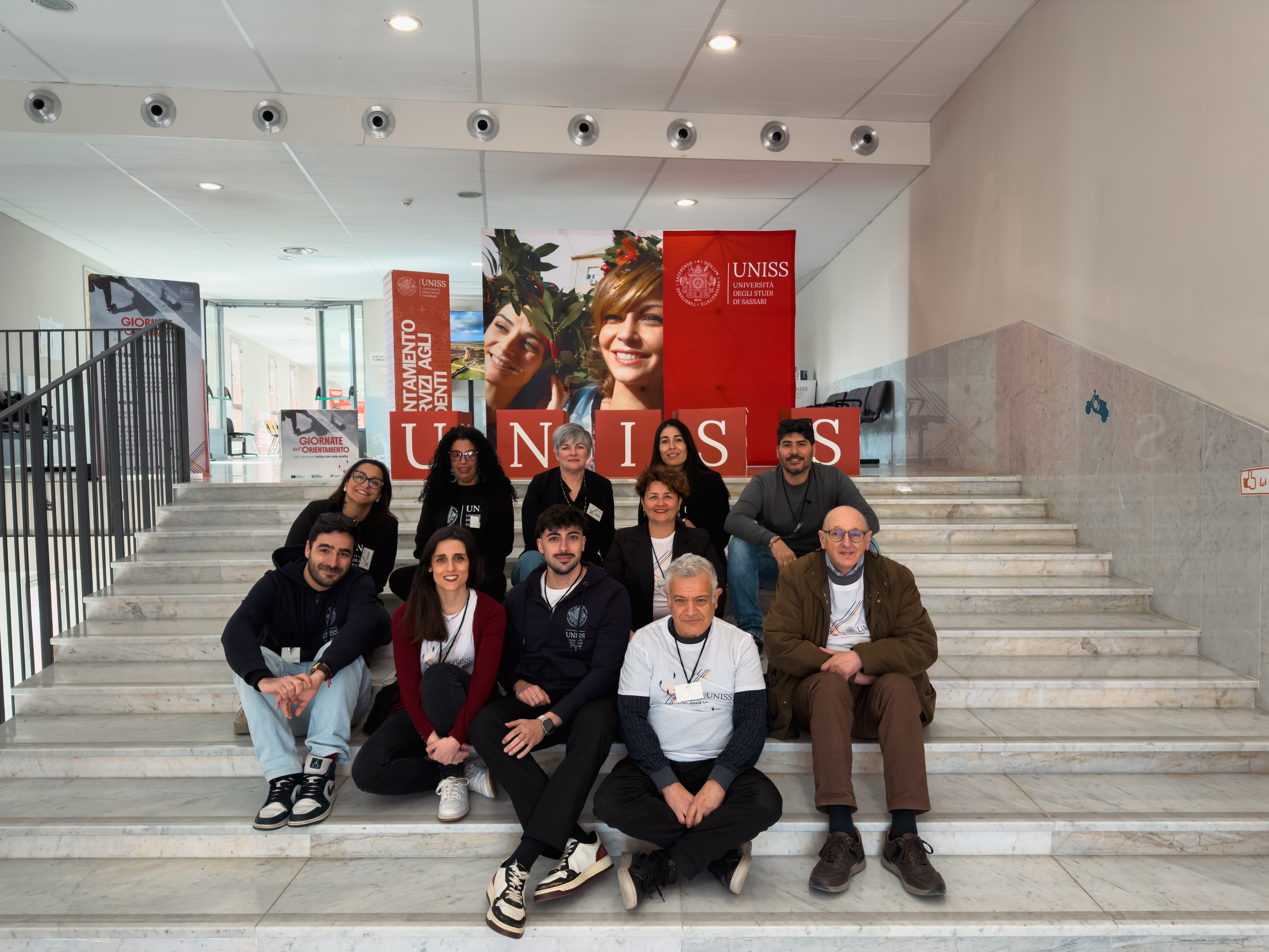 Foto di gruppo durante le Giornate dell’Orientamento UNISS all’Università di Sassari, con studenti e staff riuniti sulle scale interne dell’ateneo