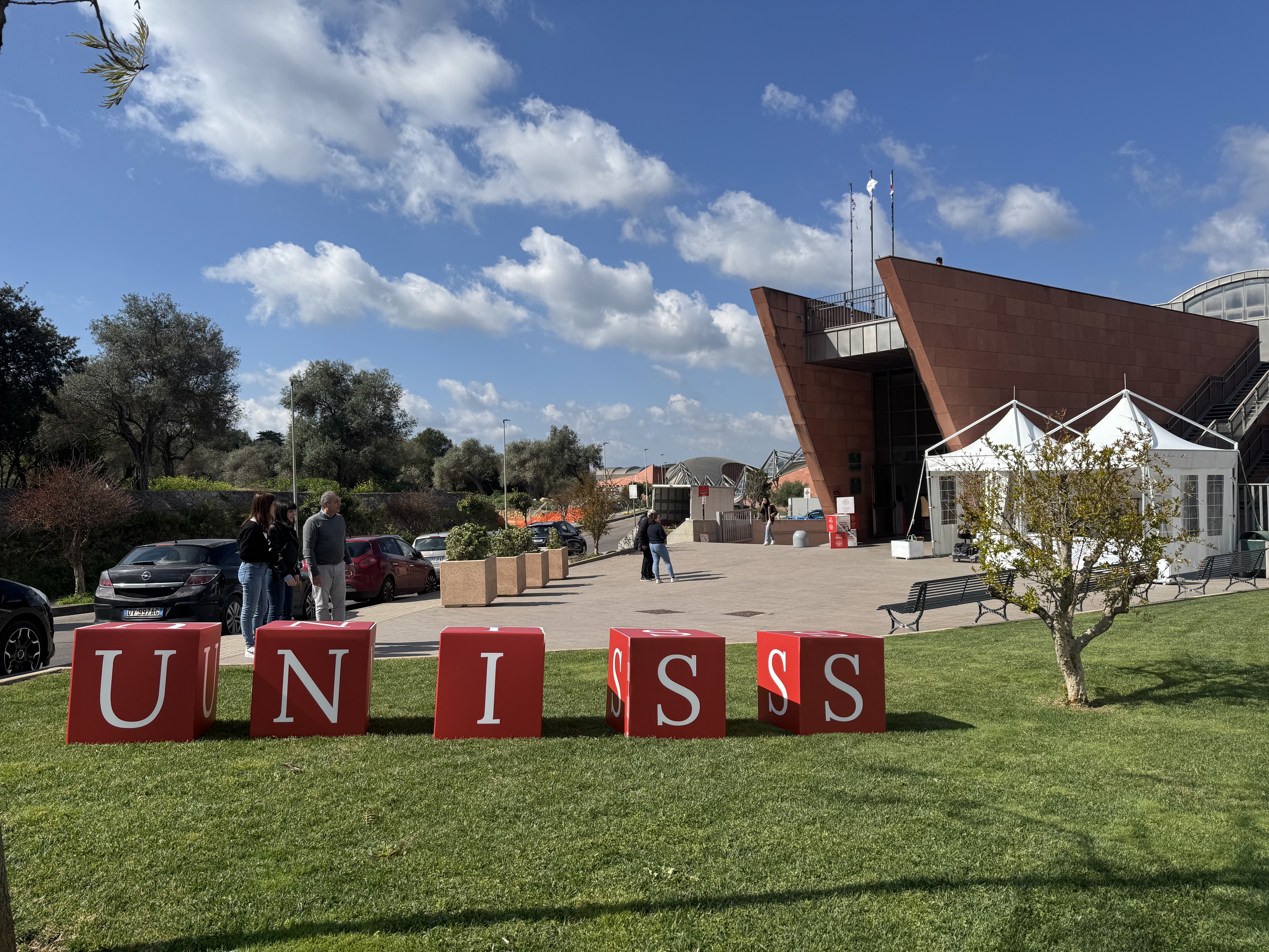 Spazio esterno del campus UNISS con installazione delle lettere dell’ateneo sul prato e area eventi all’aperto durante l’orientamento
