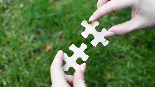 Due mani che incastrano dei tasselli si un puzzle