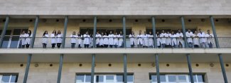 Studenti in camice bianco sul balcone di un Dipartimento
